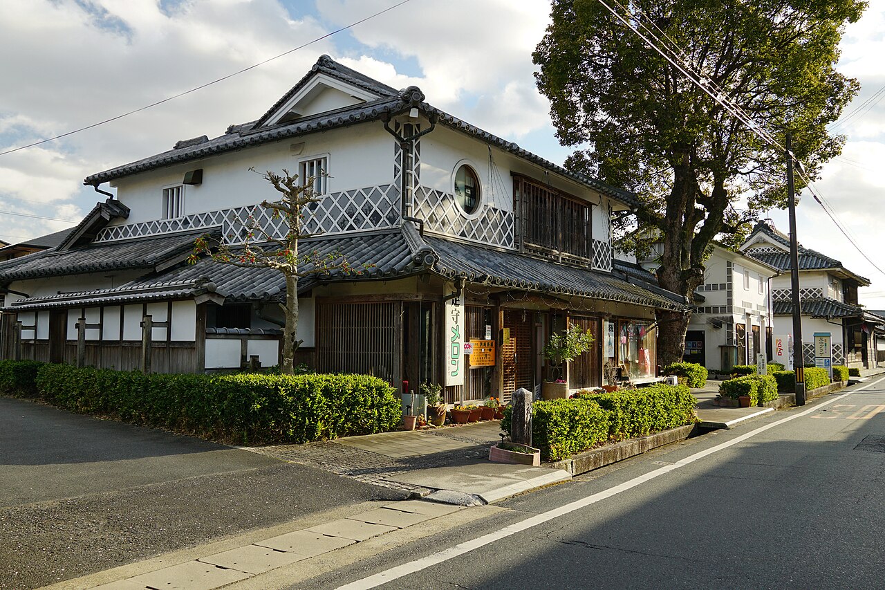 The street-facing exterior of Ashimori Plaza in December 2021, with tiled roofs and white plaster walls.
